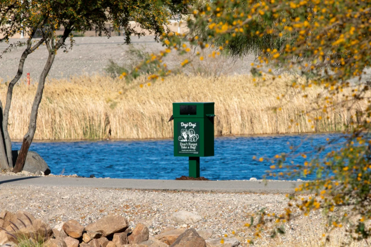 Dogi-Dogi pet waste station beside a walking path and water feature